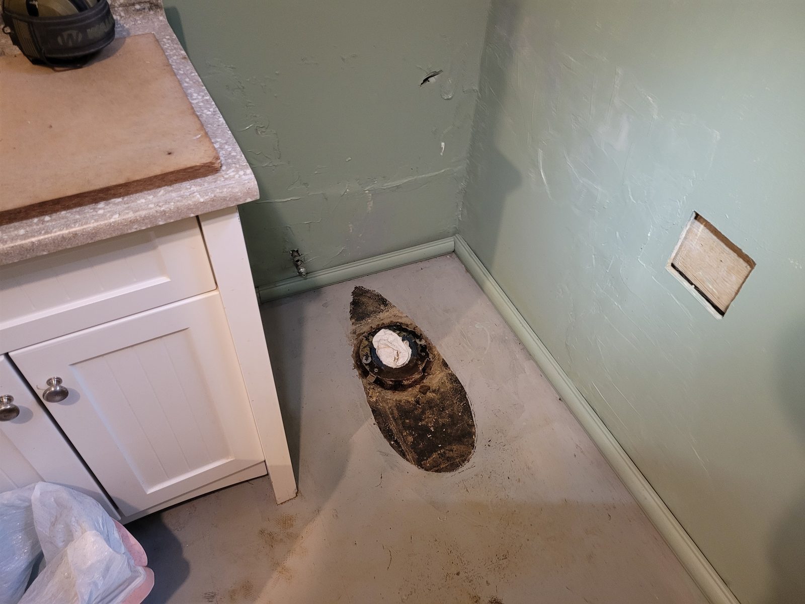 Toilet pulled to expose the closet flange and open up access to the sewer line